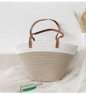 Detail of contrast color woven tote bag with leather handle on white mesh fabric background
