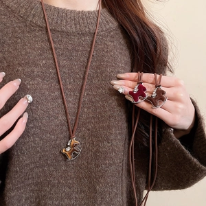 Detail of red and brown velvet rocking horse pendant on a long adjustable cord