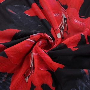 Detailed macro view of red floral print on breathable black mesh fabric texture