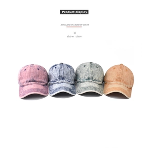 Detail view of washed denim baseball caps in four vintage colors with cotton canvas texture