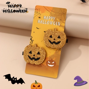 Close-up of golden glitter pumpkin hair clips with Happy Halloween display card