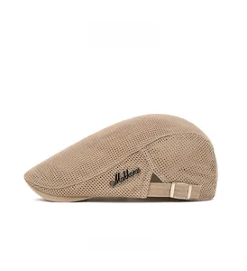 Close-up of beige mesh flat cap showing breathable fabric texture and metal side logo