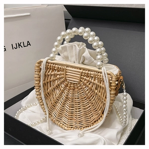 Close-up of handmade bamboo woven bag with pearl handles and drawstring inner lining