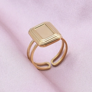 Detail of a 14k gold-plated 304 stainless steel rectangular ring on silk fabric
