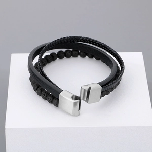 Detail of multi-layer black leather bracelet with volcanic stones and steel clasp