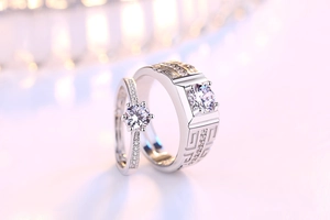 Macro shot of couple's silver open rings with square and round zircon stone settings