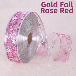 Detail of rose red organza ribbon with gold stamped stars and musical notes design