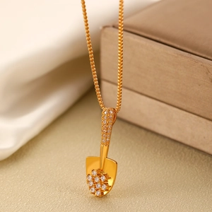 Elegant gold shovel pendant necklace with sparkling rhinestones on a silk background