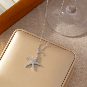Macro shot of silver starfish pendant necklace with micro-pave crystals on jewelry box