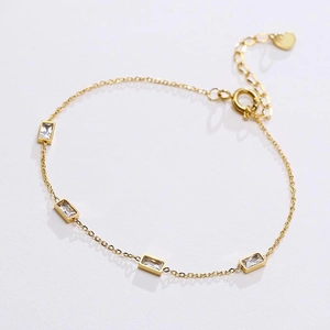 Detailed macro view of gold titanium steel necklace with rectangular zircon and heart charm