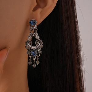 Vintage palace style drop earrings with navy blue gems, pearls and tassels on model