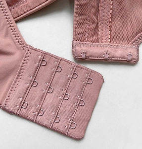 Macro shot of 4-row back closure and breathable mesh on dusty pink push-up bra