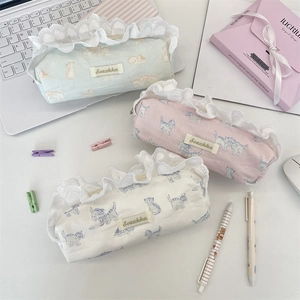 Detail showing lace trim and cat print on portable canvas pencil bags in three soft colors