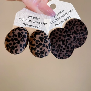 Close-up of leopard print flocked oval earrings featuring hypoallergenic S925 silver needles