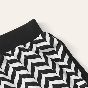 Three-piece striped swimwear featuring high-waisted black and white wave pattern bottoms