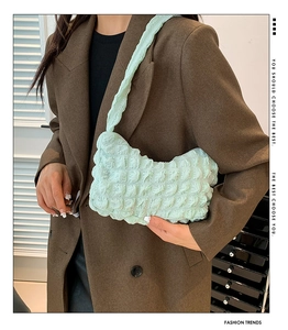 Gros plan sur la texture bouffante vert menthe d'un sac à bandoulière en croissant