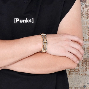 Macro detail of men's chunky punk metal bracelet with gold and silver cable textures