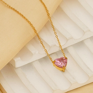 Elegant gold plated necklace with a pink heart zircon pendant on white silk fabric