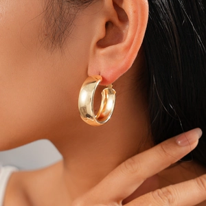 Close-up of elegant gold circular hoop earrings featuring a polished metallic finish