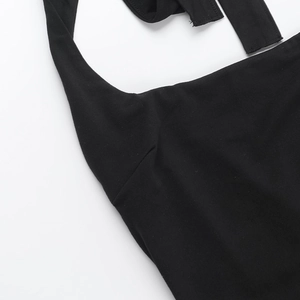 Detailed close-up of the neckline and stitching on a black halter-neck romper