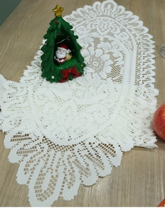 Close-up of white lace table runner with intricate hollow patterns and scalloped edges
