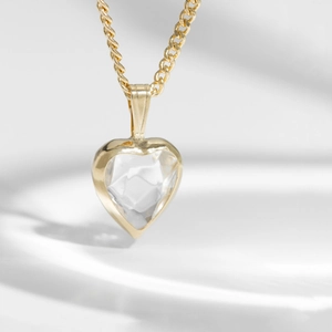 Close-up of S925 silver gold chain necklace with a sparkling heart-shaped topaz pendant