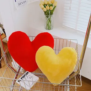 Nordic heart-shaped plush pillows in red and yellow displayed in a decorative cart