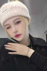 Close-up of minimalist titanium steel ball bracelet worn by model with beige knit hat