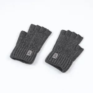 Detail of dark grey knitted fingerless gloves with ribbed cuffs and leather deer patch