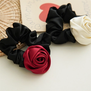 Detail of satin fabric rose flowers on handmade elastic hair scrunchies in red and beige