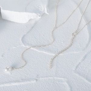 Detail of S925 silver Y-shaped necklace featuring a white teardrop pearl pendant