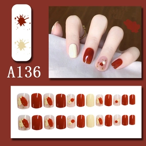 Short square press-on nails in burgundy and cream white with gold foil accents