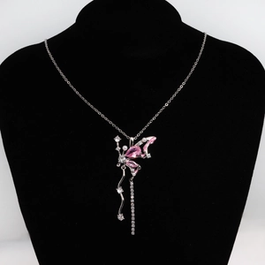 Détail d'un pendentif papillon avec cristaux roses et glands en zircone sur buste noir
