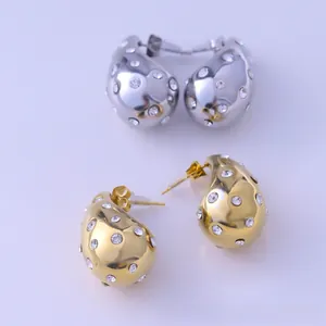 Macro shot of gold and silver liquid lava waterdrop earrings with inlaid crystals