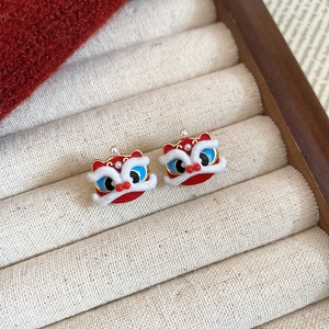 Detail of red and blue Chinese lion dance earrings with white fur trim and gold accents