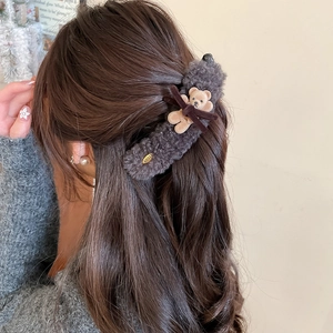 Detail of plush grey bear hair claw clip with a cute brown bow for elegant hairstyles