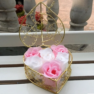 Pink and white soap roses in a heart-shaped gold wire basket on a park bench