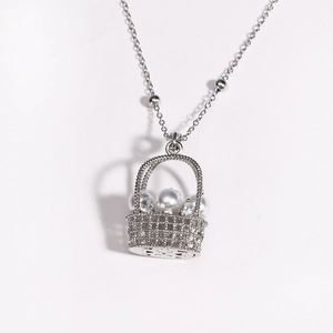 Gros plan détaillé d'un pendentif panier en argent avec perles blanches et oxydes de zirconium