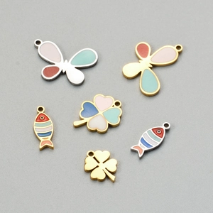 Detailed macro view of colorful enamel butterfly clover and fish charms for DIY jewelry