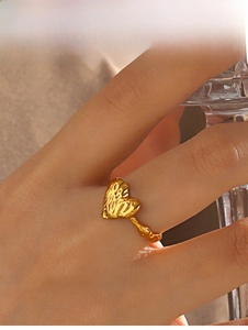 Detail of vintage heart ring with lava texture finish on a golden stainless steel band