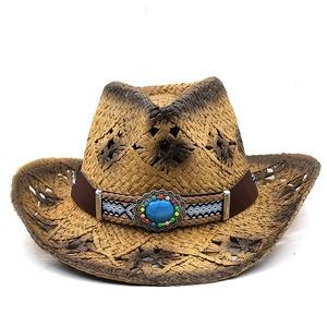 Détail d'un chapeau de cowboy en paille avec turquoise bleue et bandeau ethnique