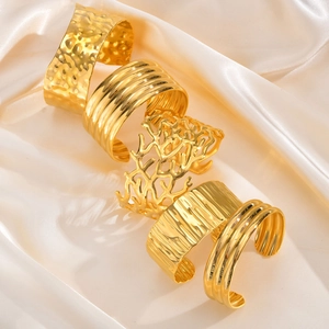Exaggerated wide gold stainless steel open bangles with hammered and textured patterns