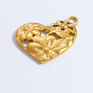 Detail macro view of a golden heart-shaped pendant with intricate floral engravings