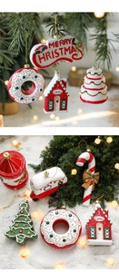 Close-up of festive red and white painted wooden Christmas ornaments on a tree branch