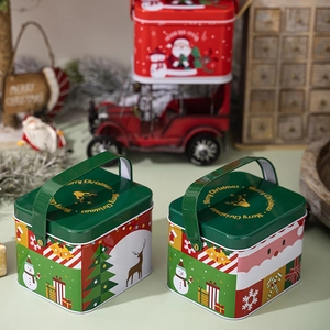 Detailed view of Christmas tin gift boxes with Santa and reindeer motifs in red and green