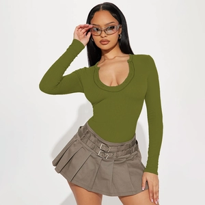 Detail view of olive green ribbed knit bodysuit with U-neck and pleated skirt with double belt
