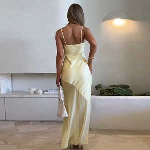 Detail of elegant pale yellow satin dress with sheer mesh panel and refined backless cut
