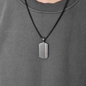 Mens minimalist silver rectangular pendant necklace with vertical stripes on grey t-shirt