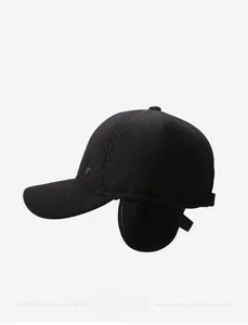 Detail of black winter baseball cap with ear flaps and side metal diamond emblem