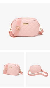 Detail of pink quilted camera bag with gold zipper and adjustable wide strap